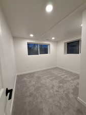 Carpeted empty room with baseboards and recessed lighting