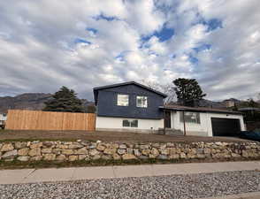 Tri-level home featuring a garage and driveway