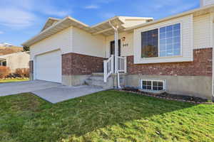 View of front facade featuring brick siding, driveway, and a front lawn