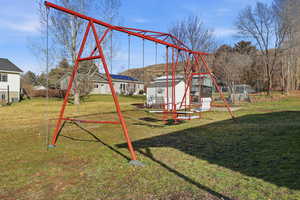 View of jungle gym featuring an outbuilding and a lawn