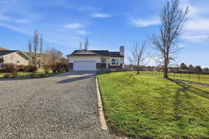 Ranch-style home with driveway, brick siding, a chimney, and a garage