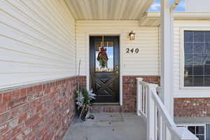 Doorway to property featuring covered porch