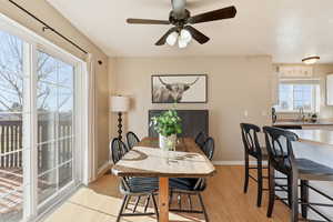 Dining space with light wood finished floors and ceiling fan
