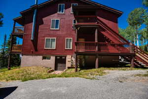 Rear view of property with stairway and a balcony