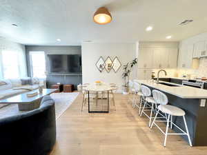 Living area featuring a textured ceiling, light wood-type flooring, and recessed lighting