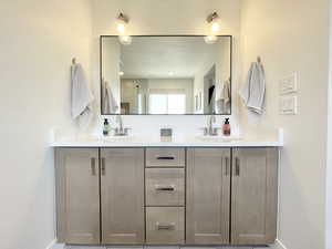 Full bathroom featuring double vanity and a shower with door