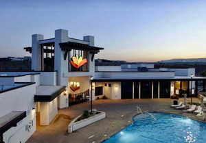 Rear view of property with a patio area, a community pool, and stucco siding