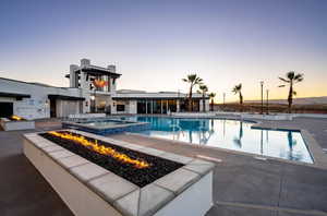 View of pool featuring a patio area, an outdoor fire pit, and a pool with connected hot tub