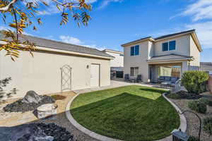 Back of house with a patio area, a lawn, a tile roof, and stucco siding
