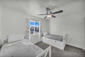 Carpeted bedroom with baseboards and a ceiling fan