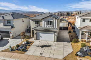 View of front of property with a tiled roof, an attached garage, board and batten siding, and a mountain view