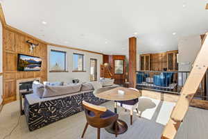 Carpeted living area with stairs, ornamental molding, recessed lighting, and a fireplace