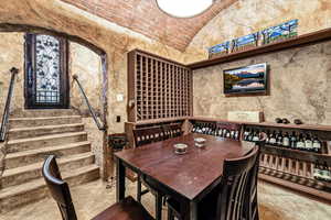 Wine area featuring brick ceiling and lofted ceiling