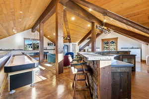 Kitchen featuring finished concrete flooring, a breakfast bar area, open floor plan, pendant lighting, and wood ceiling