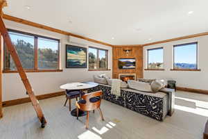 Carpeted living area with a lit fireplace, ornamental molding, a wall unit AC, and recessed lighting