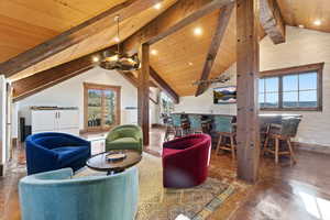 Sitting room with a wooden ceiling with exposed beams, high vaulted ceiling, and concrete flooring