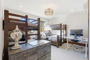 Bedroom featuring an office area, light colored carpet, a wall mounted AC, and recessed lighting