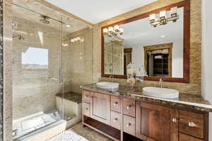 Bathroom featuring a shower stall, double vanity, and recessed lighting