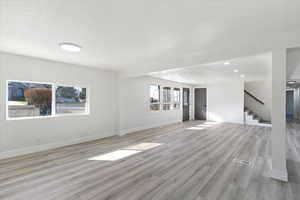 Unfurnished living room with stairway, recessed lighting, and light wood finished floors