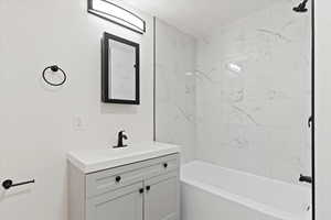 Bathroom with vanity and bathtub / shower combination