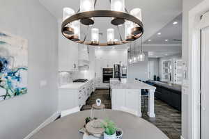 Dining area featuring dark wood-type flooring, recessed lighting, and a chandelier