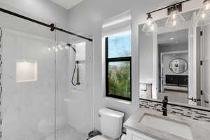 Bathroom featuring vanity and a marble finish shower