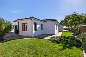 Rear view of house with stucco siding and a patio