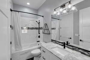 Full bath with shower / bath combination with curtain, vanity, and recessed lighting