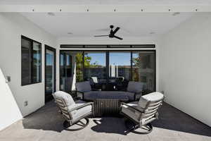 View of patio featuring ceiling fan, a sunroom, and an outdoor hangout area
