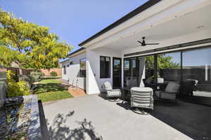 Fenced backyard featuring ceiling fan, a patio area, and outdoor dining area