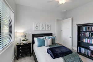 Carpeted bedroom featuring baseboards and ceiling fan