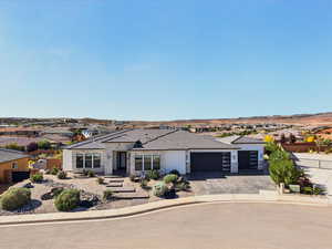 View of front facade with stone siding, stucco siding, asphalt driveway, an attached garage, and a residential view