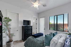 Bedroom with carpet floors, access to exterior, ceiling fan, and ensuite bath
