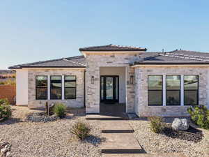 View of front of home featuring stone siding and a tiled roof