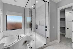 Full bathroom featuring a bath, a marble finish shower, a spacious closet, and recessed lighting