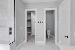 Full bathroom with a walk in closet and a tile shower