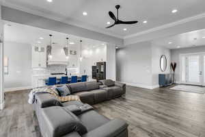 Living room featuring ceiling fan, recessed lighting, light wood-type flooring, and ornamental molding