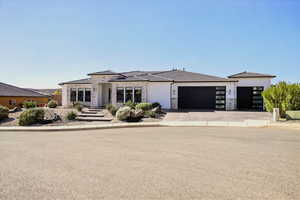 Prairie-style home featuring a garage, concrete driveway, stucco siding, a tiled roof, and stone siding