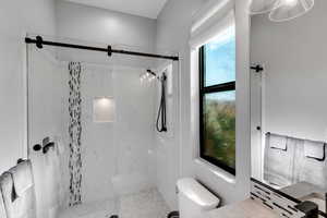 Full bath featuring a marble finish shower and vanity