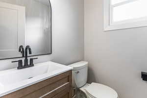 Half bathroom with vanity and toilet