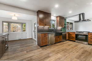 Kitchen with granite countertops, extractor fan, recessed lighting, stainless steel dishwasher, and a dining nook.