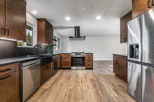 Kitchen with granite countertops, extractor fan, recessed lighting, stainless steel dishwasher, and a peninsula