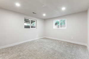 Carpeted empty room featuring baseboards and recessed lighting