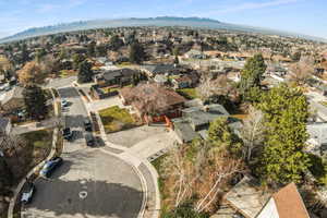 Aerial view of property and surrounding area with nearby suburban area and a mountainous background