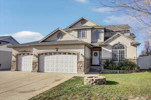 View of front of property featuring stone siding, stucco siding, driveway, a garage, and a shingled roof