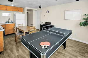 Playroom with light wood finished floors and a textured ceiling