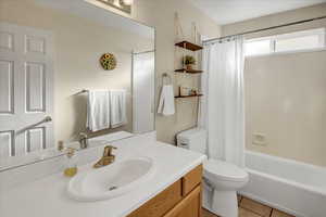 Bathroom featuring vanity, shower / bath combo, and light tile patterned floors