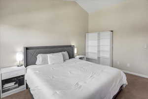 Bedroom with carpet floors and vaulted ceiling