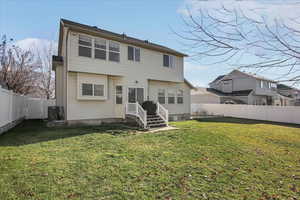 Back of house featuring a fenced backyard and entry steps