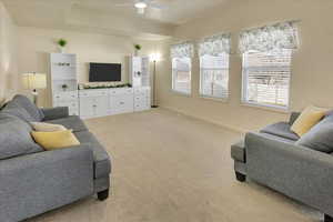Living room with light colored carpet and ceiling fan